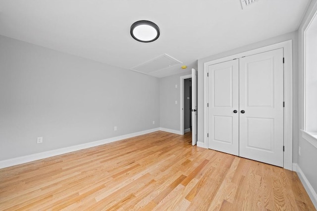 unfurnished bedroom with light hardwood / wood-style floors and a closet