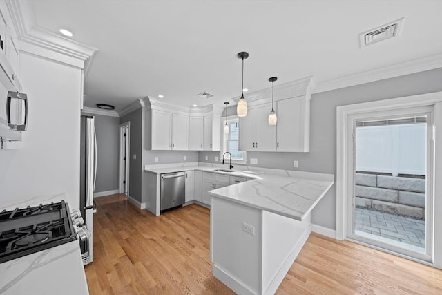 kitchen with white cabinets, sink, appliances with stainless steel finishes, light stone counters, and kitchen peninsula