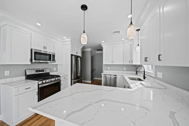 kitchen with kitchen peninsula, stainless steel appliances, white cabinetry, and hanging light fixtures