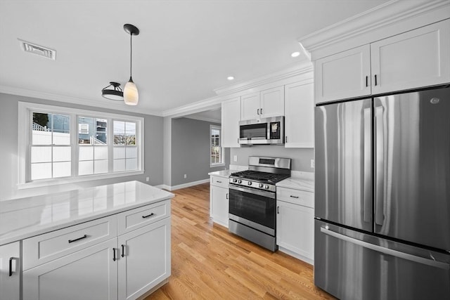 kitchen featuring white cabinets, appliances with stainless steel finishes, light stone counters, and crown molding