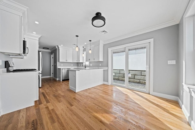 kitchen featuring white cabinets, decorative light fixtures, ornamental molding, and stainless steel appliances