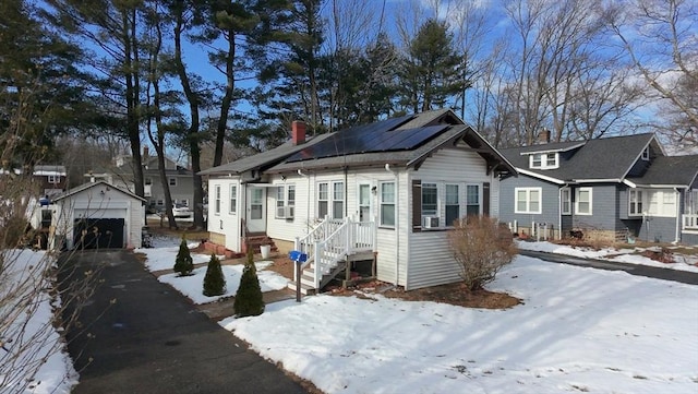 view of front of property with a garage, an outdoor structure, and solar panels