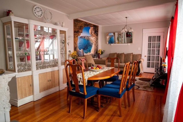 dining area featuring beamed ceiling and wood-type flooring