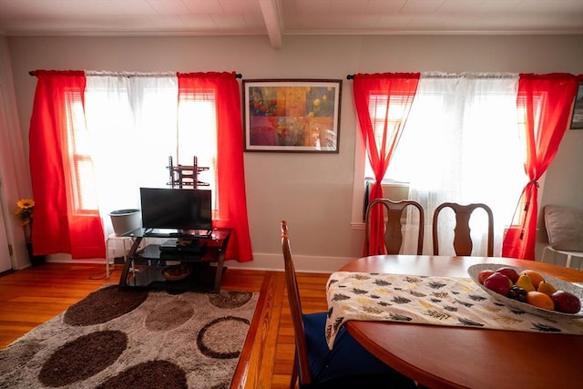 dining room featuring wood-type flooring and beamed ceiling