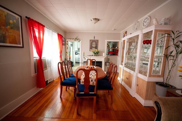 dining room with wood-type flooring and crown molding