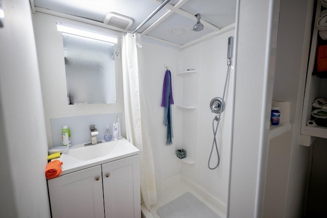 bathroom featuring walk in shower and vanity