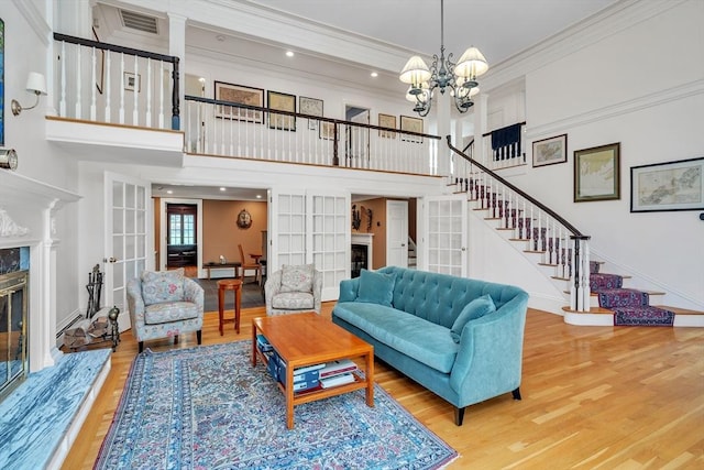 12 Old Meadow Rd, Dover, MA 02030 - living room featuring a fireplace, ornamental molding, stairway, a high ceiling, and wood finished floors