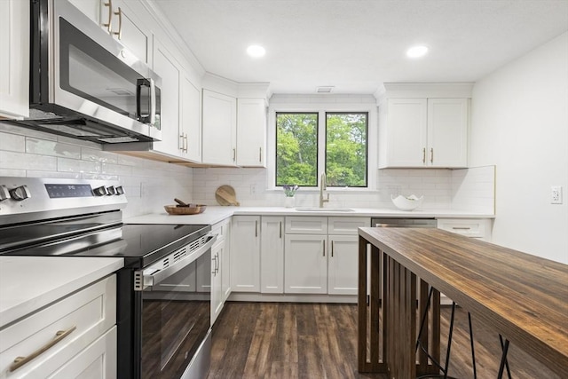 24 Roosevelt St, Taunton, MA 02780 - kitchen featuring appliances with stainless steel finishes, a sink, dark wood finished floors, white cabinetry, and recessed lighting