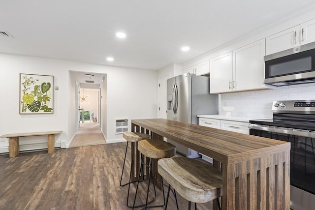 24 Roosevelt St, Taunton, MA 02780 - kitchen featuring stainless steel appliances, white cabinets, decorative backsplash, dark wood-style floors, and baseboards