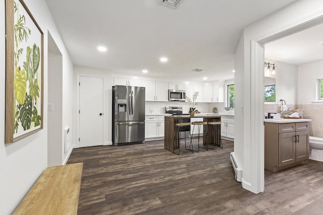 24 Roosevelt St, Taunton, MA 02780 - kitchen featuring appliances with stainless steel finishes, a baseboard heating unit, healthy amount of natural light, dark wood-style flooring, and recessed lighting