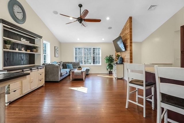 living area with ceiling fan, visible vents, vaulted ceiling, and dark wood-style flooring