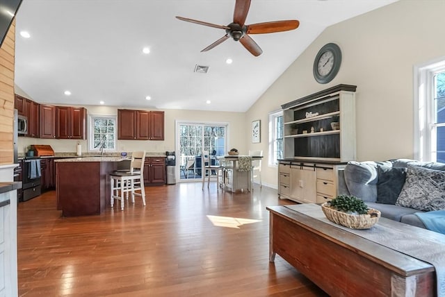 living room with visible vents, plenty of natural light, and hardwood / wood-style flooring