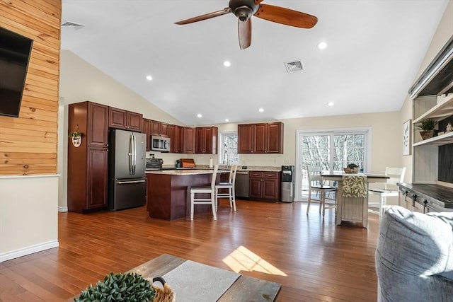 kitchen featuring dark wood-style floors, a center island, visible vents, appliances with stainless steel finishes, and open floor plan