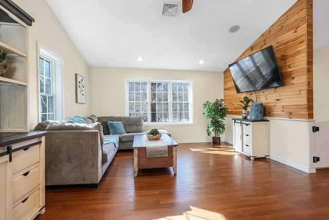 living area featuring vaulted ceiling, dark wood-style flooring, visible vents, and recessed lighting