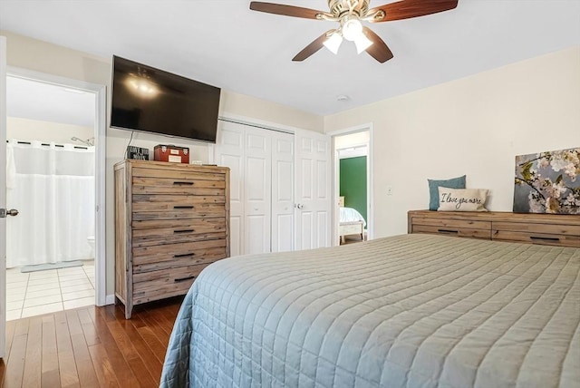 bedroom with ensuite bath, dark wood-style flooring, a closet, and a ceiling fan