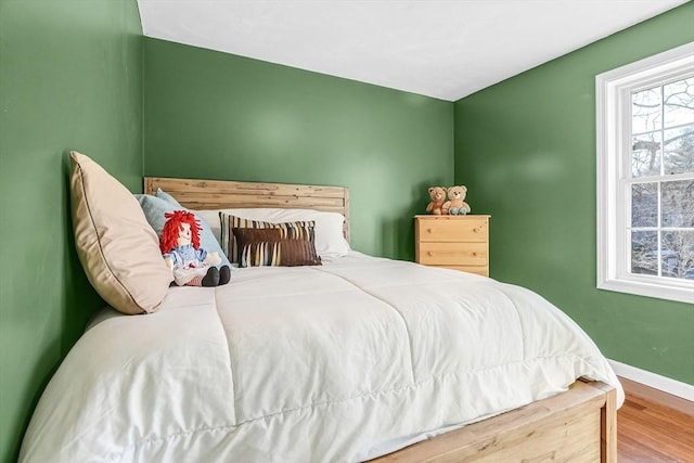 bedroom featuring wood finished floors and baseboards