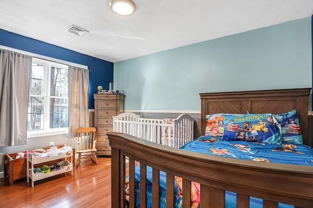 bedroom featuring visible vents and wood finished floors