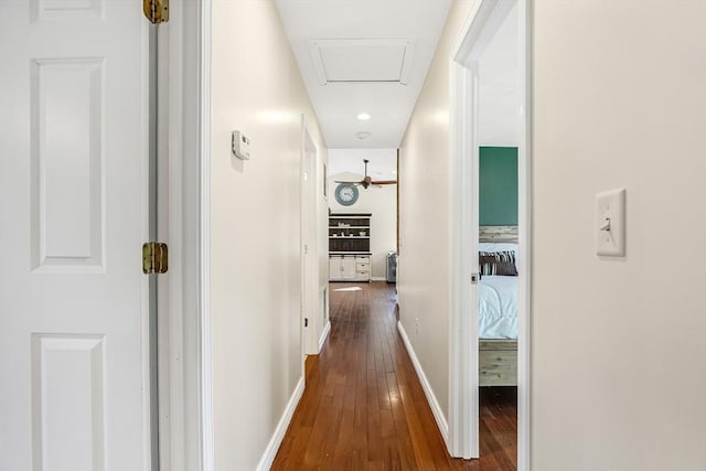 hall featuring attic access, baseboards, and hardwood / wood-style floors