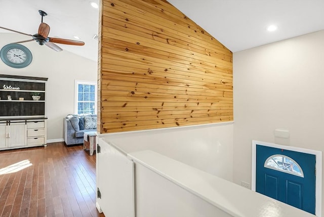 hallway featuring dark wood finished floors, vaulted ceiling, and recessed lighting