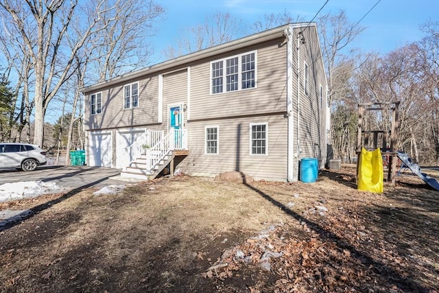 view of front of house with a playground, driveway, and an attached garage