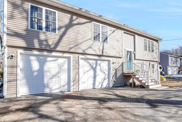 view of front of home featuring an attached garage and aphalt driveway