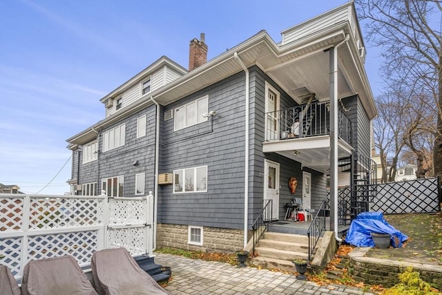 rear view of house featuring a balcony and a patio