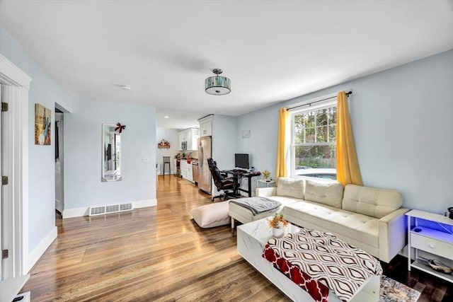 60 Grove St, Barnstable, MA 02601 - living area with light wood-style flooring, baseboards, and a desk