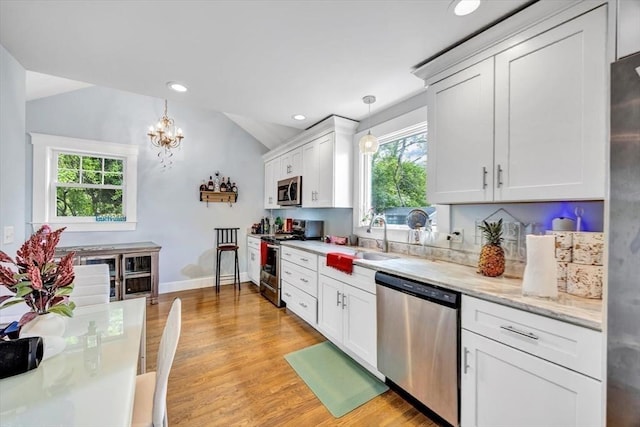 60 Grove St, Barnstable, MA 02601 - kitchen with appliances with stainless steel finishes, lofted ceiling, healthy amount of natural light, a sink, and light wood-type flooring
