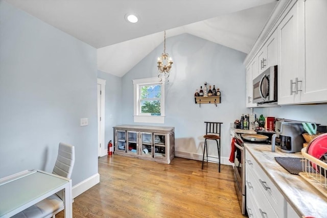 60 Grove St, Barnstable, MA 02601 - kitchen featuring appliances with stainless steel finishes, light countertops, vaulted ceiling, a chandelier, and white cabinetry