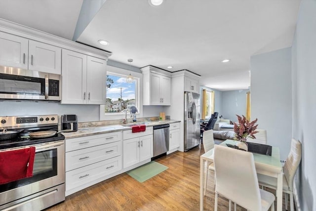 60 Grove St, Barnstable, MA 02601 - kitchen with appliances with stainless steel finishes, light countertops, recessed lighting, a sink, and white cabinets