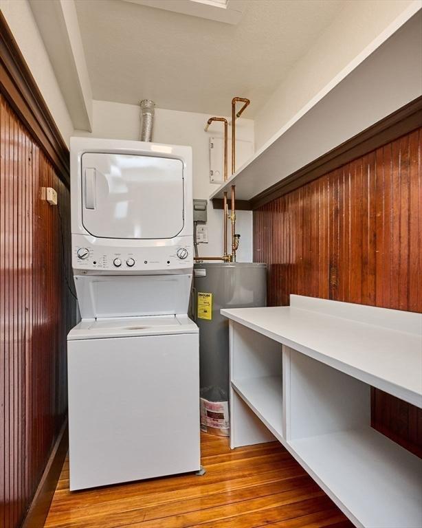 58 Main St Unit 4, Hatfield, MA 01038 - laundry area featuring stacked washer and clothes dryer, electric water heater, and light wood-type flooring