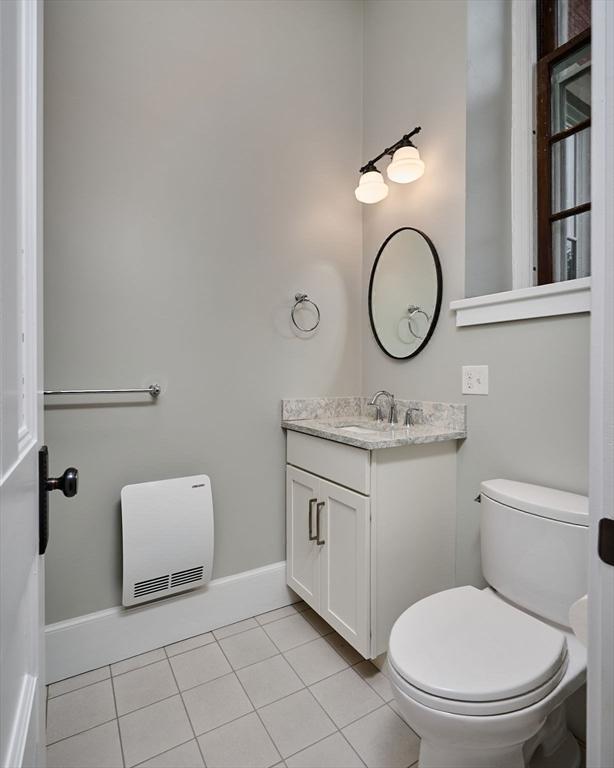58 Main St Unit 4, Hatfield, MA 01038 - half bathroom with vanity, heating unit, and tile patterned flooring