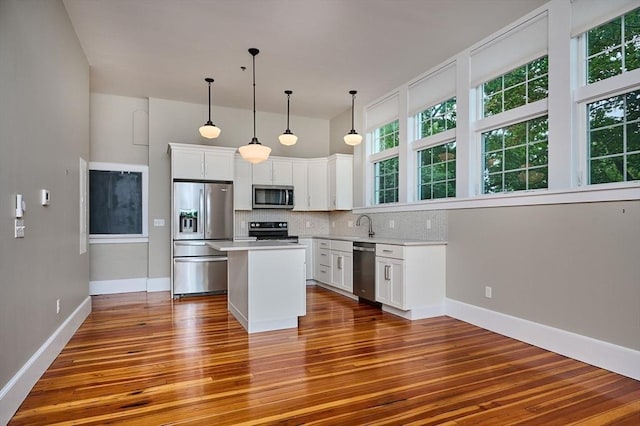 58 Main St Unit 4, Hatfield, MA 01038 - kitchen featuring appliances with stainless steel finishes, wood finished floors, tasteful backsplash, white cabinetry, and light countertops