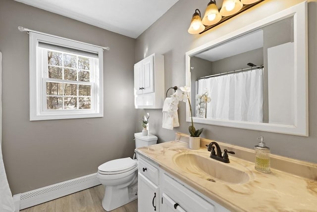 bathroom featuring a baseboard radiator, hardwood / wood-style flooring, toilet, and vanity