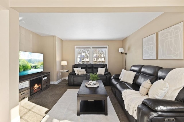 living room featuring dark carpet and a fireplace