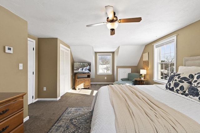 bedroom featuring ceiling fan, dark carpet, vaulted ceiling, and multiple windows