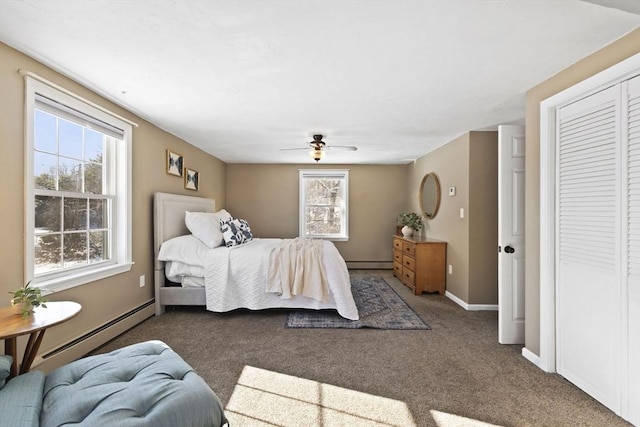 carpeted bedroom featuring a closet, ceiling fan, and a baseboard heating unit