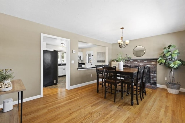 dining area with light hardwood / wood-style flooring and a notable chandelier