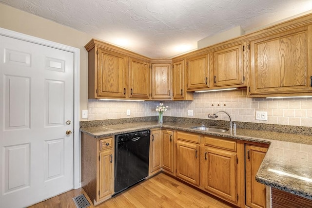 kitchen with backsplash, sink, light hardwood / wood-style flooring, a textured ceiling, and black dishwasher