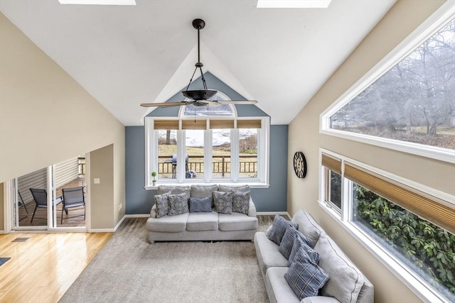 living room with hardwood / wood-style floors, lofted ceiling with skylight, and a wealth of natural light