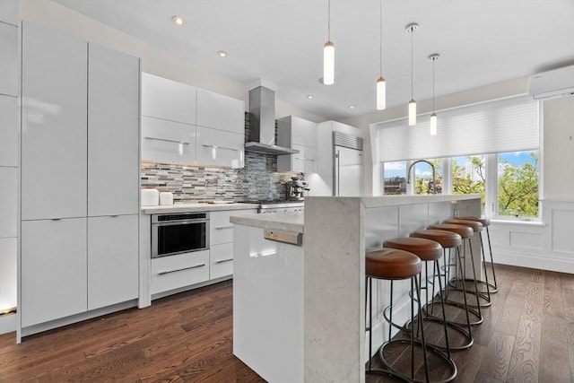 kitchen with oven, modern cabinets, wall chimney exhaust hood, dark wood-type flooring, and recessed lighting