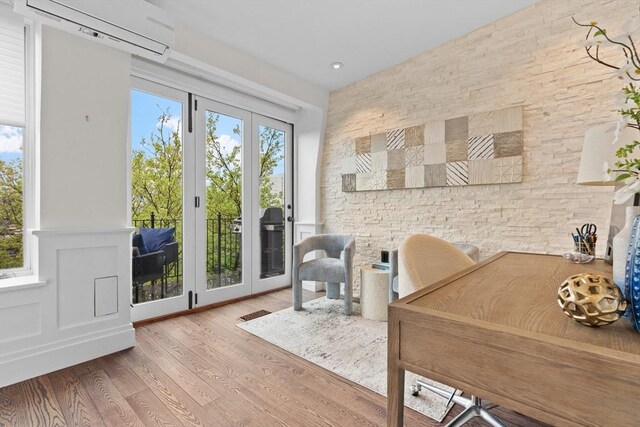 doorway to outside featuring french doors, a wall mounted air conditioner, wood finished floors, and healthy amount of natural light