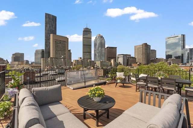 wooden deck with a view of skyline and outdoor lounge area