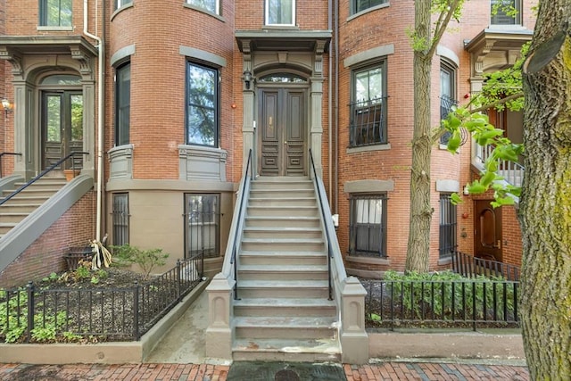 entrance to property featuring brick siding and french doors