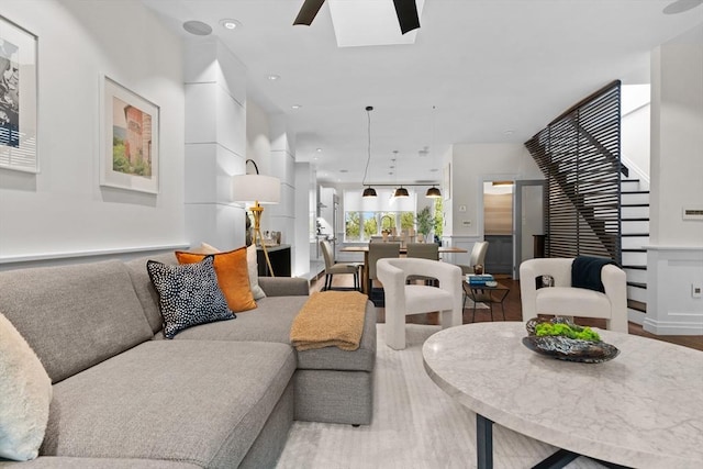 living area with wood finished floors, recessed lighting, ceiling fan, and a skylight