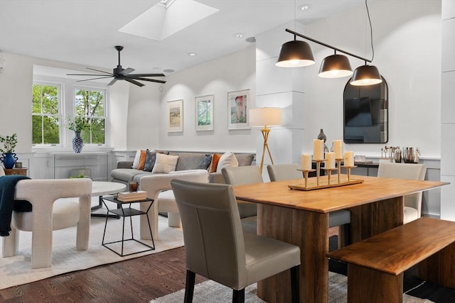 dining area with a skylight, dark wood-style floors, ceiling fan, and recessed lighting