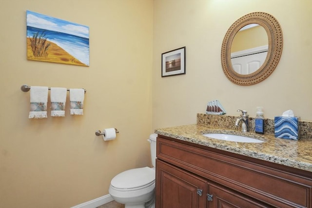 bathroom featuring vanity, baseboards, and toilet