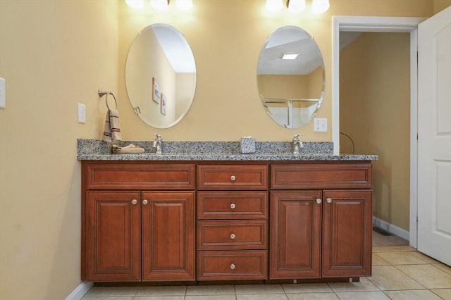full bathroom with double vanity, a sink, baseboards, and tile patterned flooring