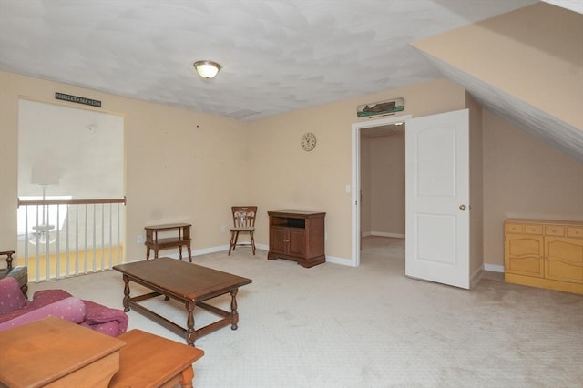 living area with baseboards and light carpet