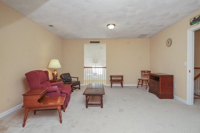 living room featuring baseboards, visible vents, and light colored carpet
